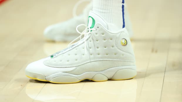 View of white and green Air Jordan shoes.